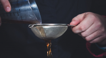 Unas manos filtrando aceite usado