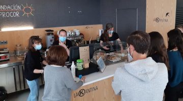 Personas en la barra de una cafetería haciendo sus pedidos.
