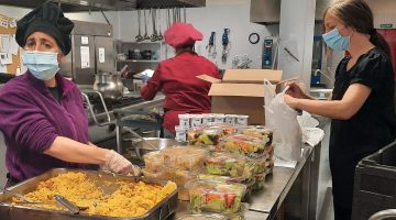 Personas con discapacidad repartiendo raciones de paella